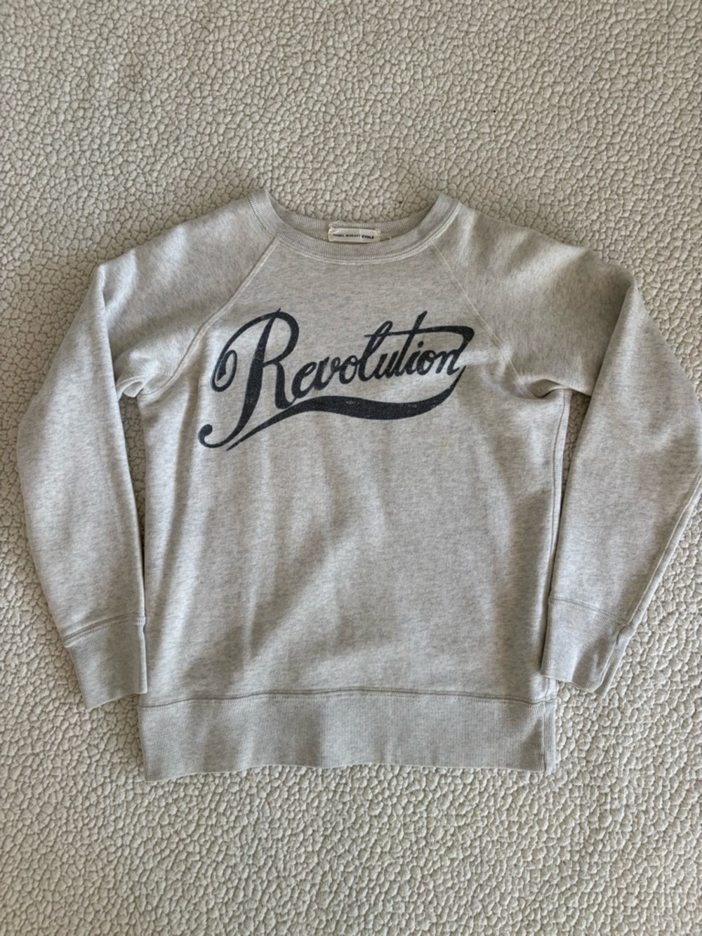Isabel Marant Étoile grey sweatshirt with “Revolution” graphic.